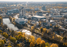 Aerial view of downtown Guelph in autumn, featuring the Speed River, historic buildings, bridges, and trees with vibrant fall foliage.