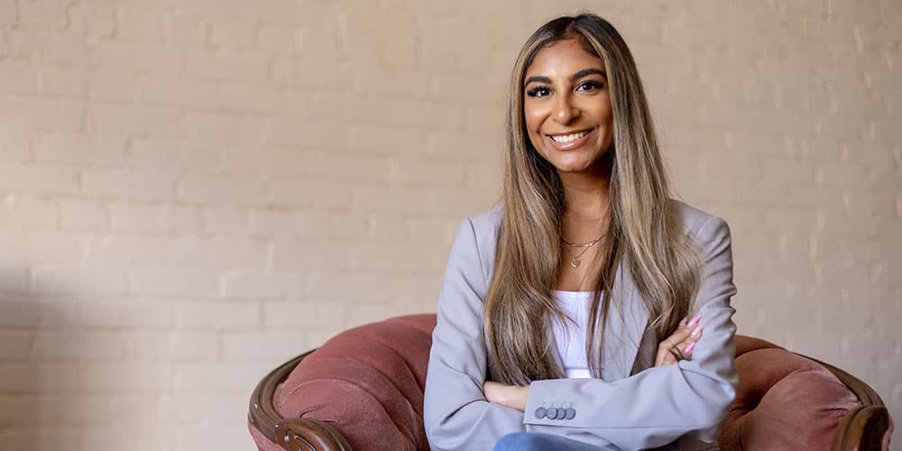 Lang business school alumni Tara Lalani sitting smiling.