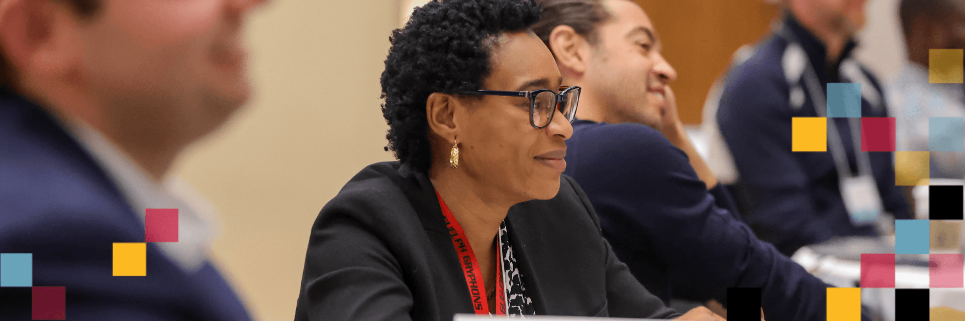 A person sitting at a table looking at the front of the room.
