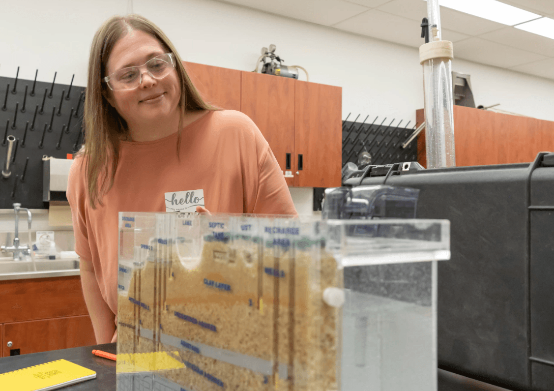 Jana Levison, PhD, P.Eng. looking at a soil purifying equipment.