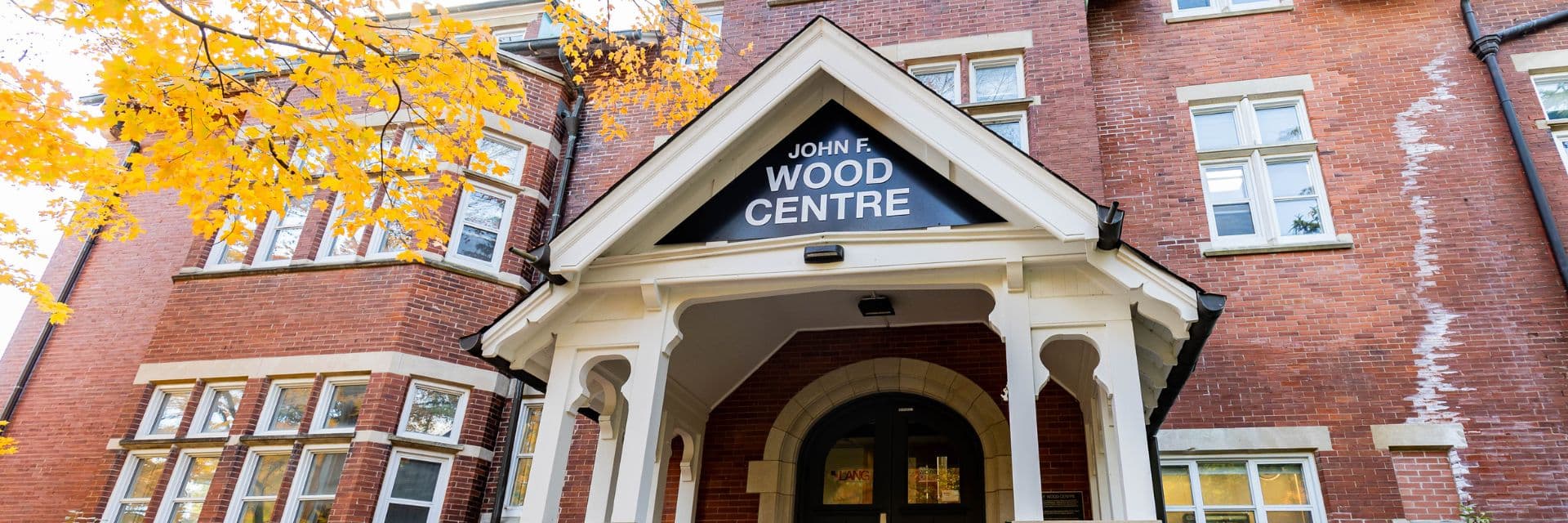 A red brick image with John F. Wood Centre text