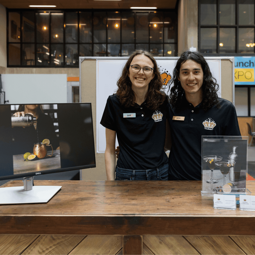 Two individuals behind booth at LaunchLab Expo Event
