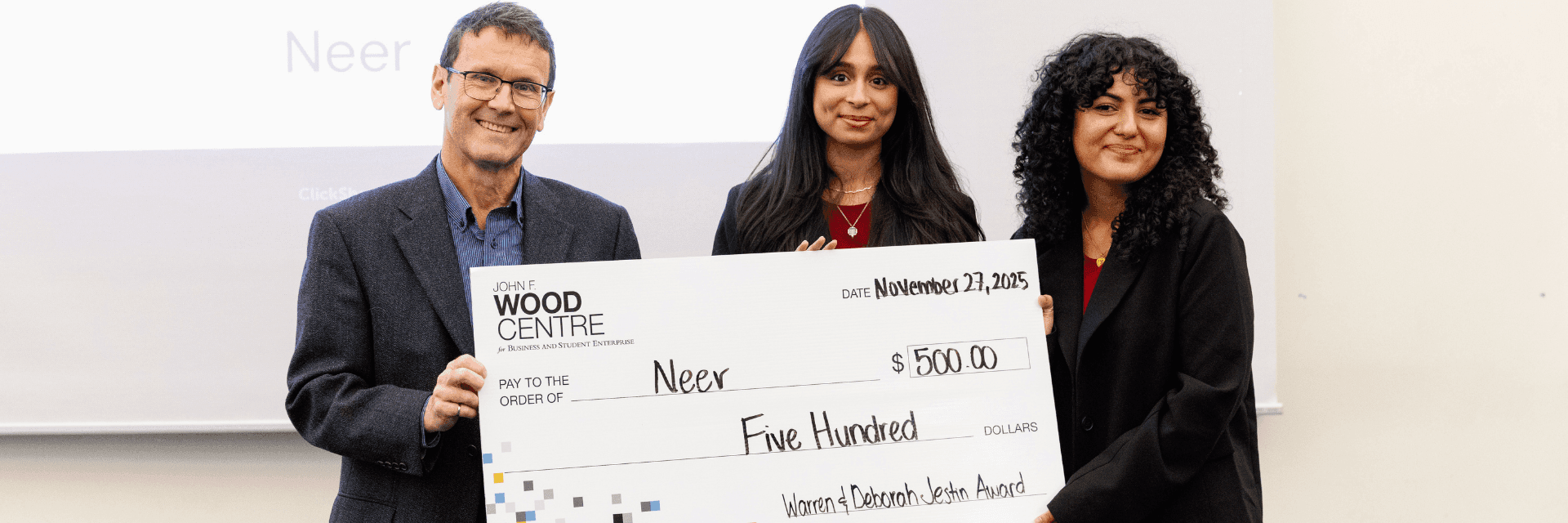 3 individuals holding cheque